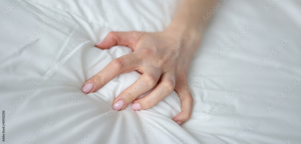 Close-up of sexy female hand pulling and squeezing white sheets in bed. Tender woman hand with sensual manicure. Sexy, pleasure and erotic concept Close-up of sexy female hand pulling and squeezing white sheets in bed. Tender woman hand with sensual manicure. Sexy, pleasure and erotic concept