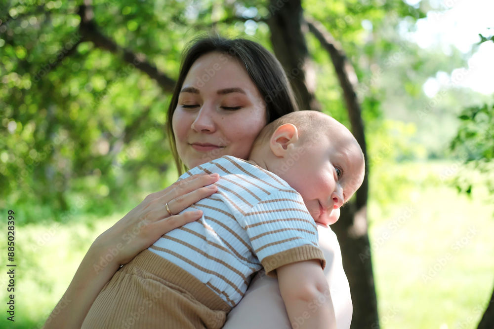 Happy mother and child hugging in summer park with love, smile and care or health development. Happy family concept. Portrait of human emotions. Advertising of children's products. Selective focus. Happy mother and child hugging in summer park with love, smile and care or health development. Happy family concept. Portrait of human emotions. Advertising of children's products. Selective focus.