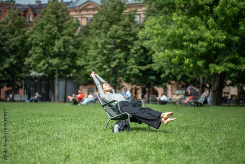 Billede på lærred Lazy woman resting on grass outside, sleeping outdoors, dozing bathing in warm sunshine