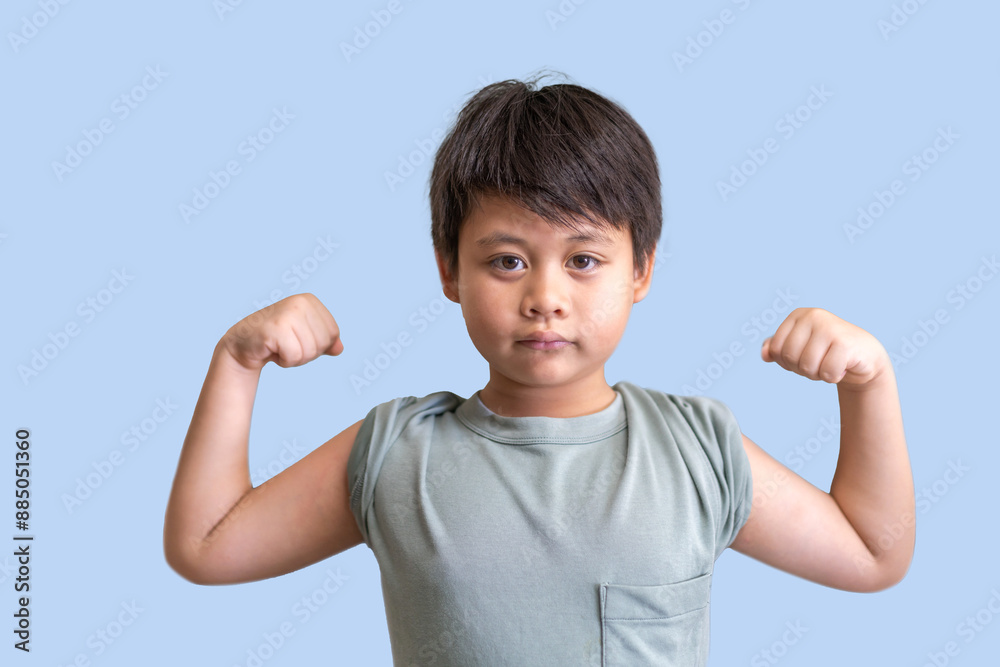 Young asian boy flexing his muscles against a light blue background showcases strong and poses with both arms flexed, childhood strength and determination, empowerment, confidence, fitness and health Young asian boy flexing his muscles against a light blue background showcases strong and poses with both arms flexed, childhood strength and determination, empowerment, confidence, fitness and health
