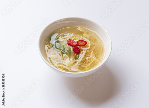 Close-up of bean sprout soup with green onion and red pepper on bowl and white floor, South Korea
 photo