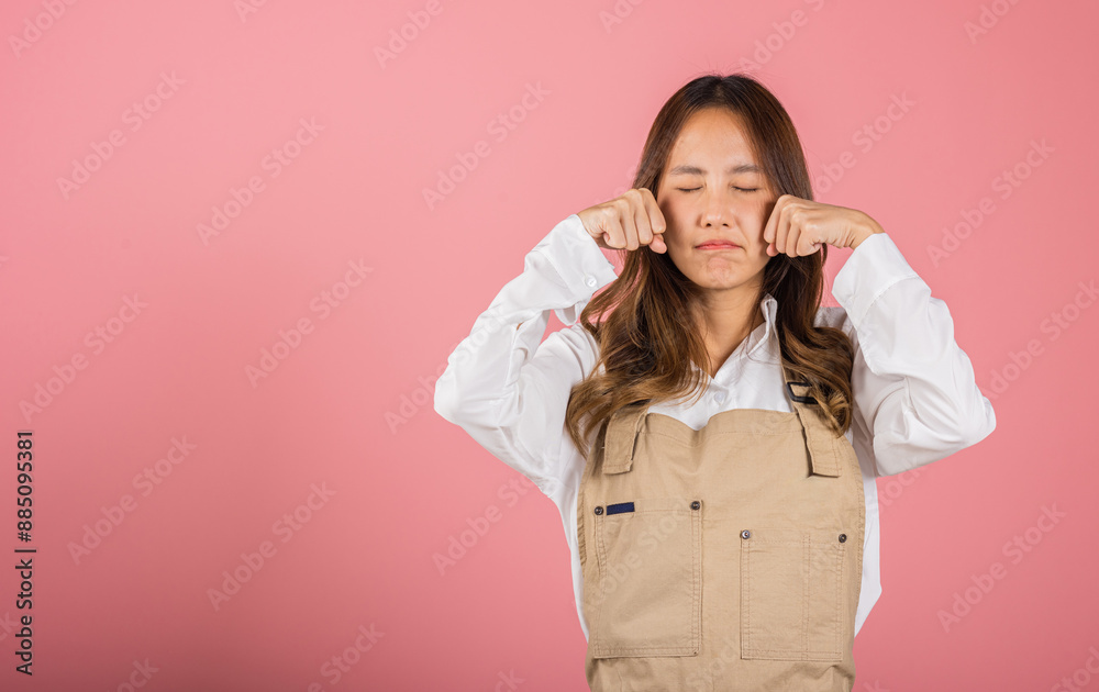 Unhappy small business woman bad mood her cry wipe tears with fingers, Asian beautiful young female stress feeling sad unhappy crying, studio shot isolated on pink background with copy space Unhappy small business woman bad mood her cry wipe tears with fingers, Asian beautiful young female stress feeling sad unhappy crying, studio shot isolated on pink background with copy space