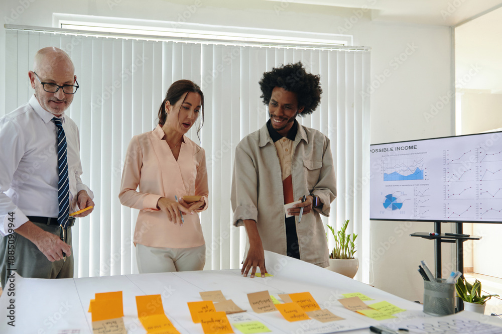 © DragonImages - Marketers discussing their notes on paper and planning working process together in office © DragonImages - Marketers discussing their notes on paper and planning working process together in office