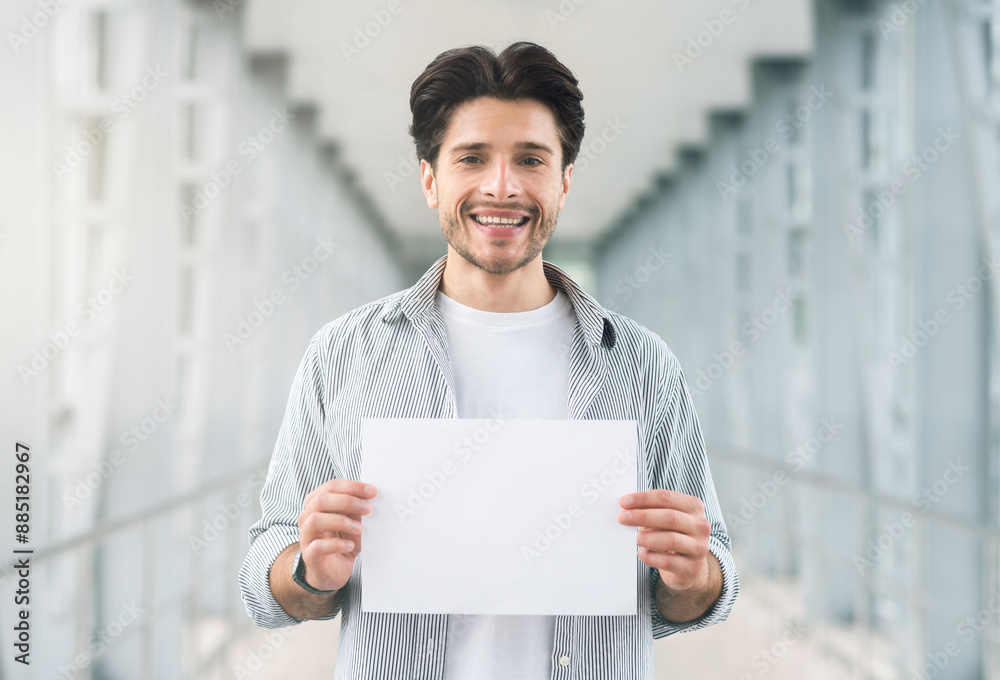 Meeting arrivals. Friendly millennial man holding name board at airport, empty space for you text Meeting arrivals. Friendly millennial man holding name board at airport, empty space for you text