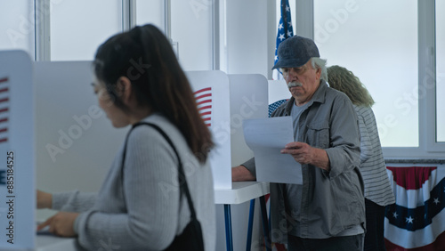 Diverse American citizens come to vote in booth in polling station office. National Election Day in the United States. Political races of presidential candidates. Concept of civic duty and patriotism. photo