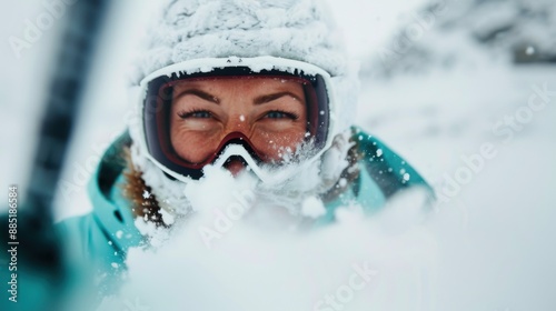 Close-up of a skier equipped with snow-covered goggles, dressed warmly in winter gear, embracing the thrill of skiing through white, powdery snow in a snowy landscape. photo