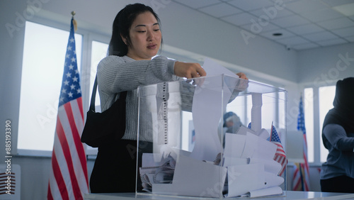 Fotografie Asian woman puts ballot paper in box
