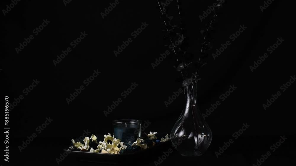 Still life of dark photo of candle and vase with black plant. Still life of dark photo of candle and vase with black plant.