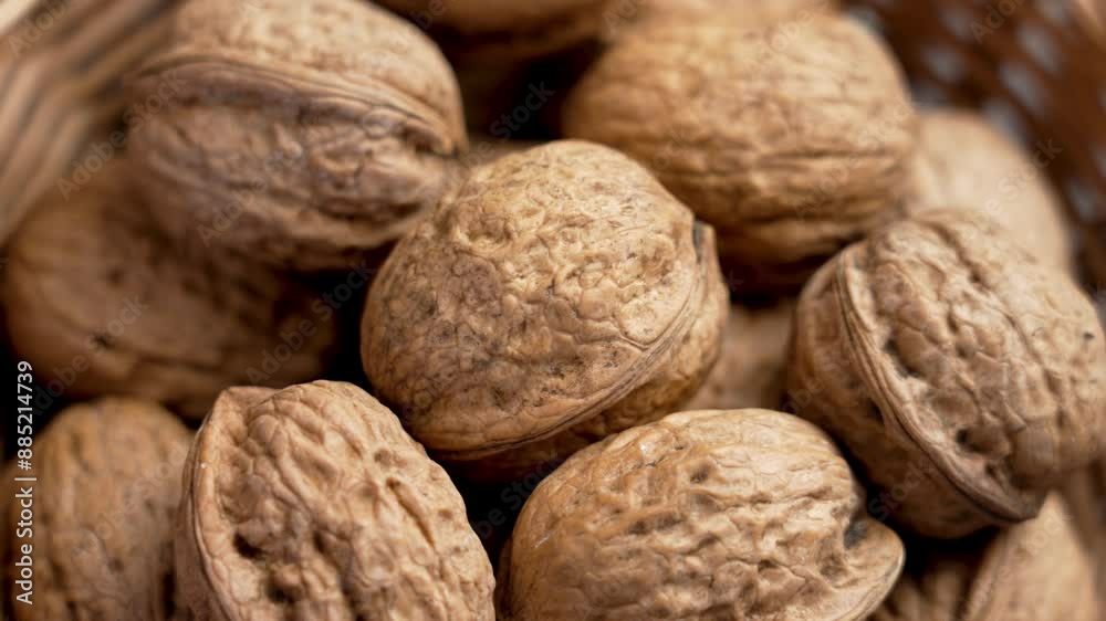 Woven basket overflowing with whole walnuts, ready to be cracked open. Organic nuts. Close up. Rotation Woven basket overflowing with whole walnuts, ready to be cracked open. Organic nuts. Close up. Rotation