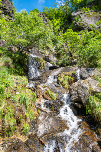 Mountain waterfall dropping from the peaks of Northern Italy Alps (Monte Rosa Massif, the 2nd highest mountain of Europe), during early summer.