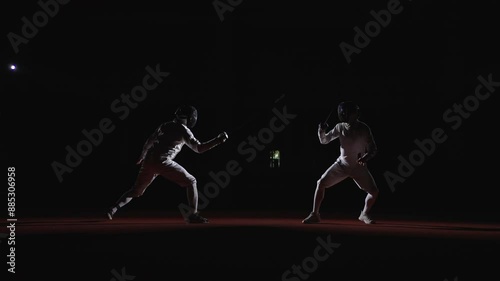 Professional Fencers With Epees Fighting On Fencing Track, View From Side In Darkness, Fencing Sport photo