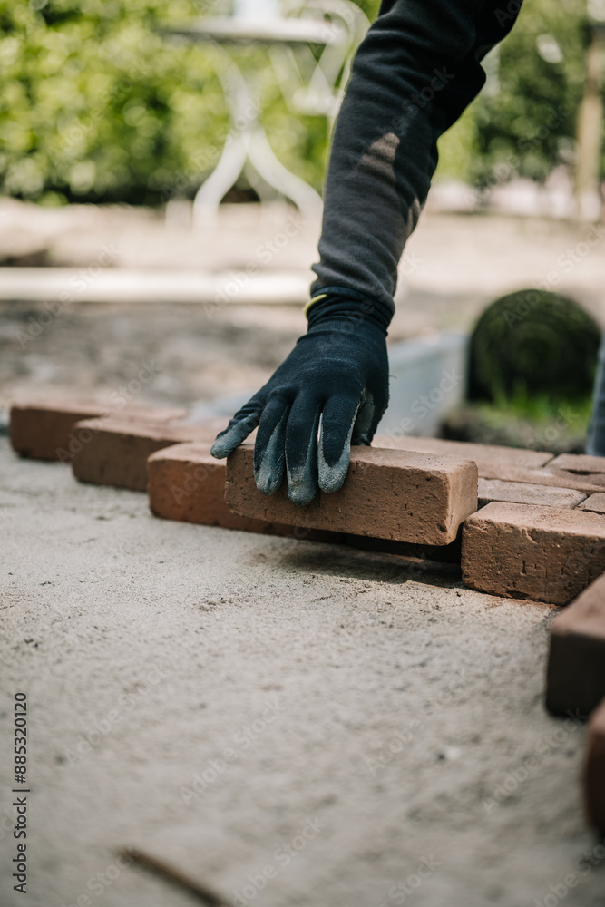 Close-up of bricklayer laying down brick for pavement sidewalk Close-up of bricklayer laying down brick for pavement sidewalk