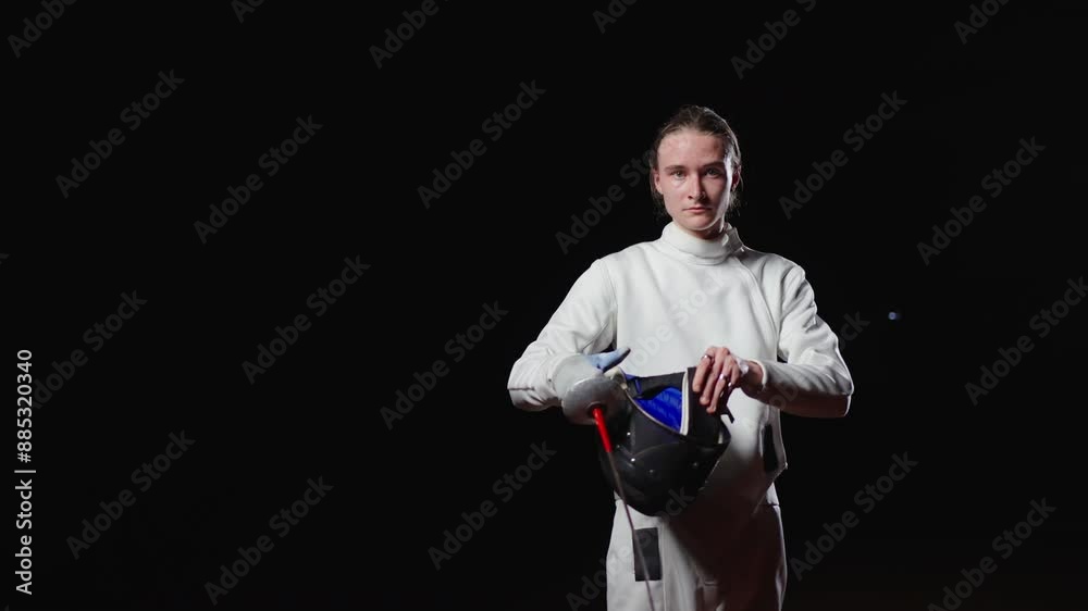 Professional Fencer In Uniform Holding Fencing Mask In Hands, Portrait In Black Background Professional Fencer In Uniform Holding Fencing Mask In Hands, Portrait In Black Background