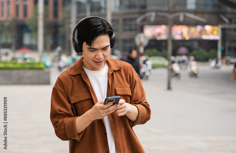Obraz premium Handsome long legs of Asian men walking, listening to music and working on the street