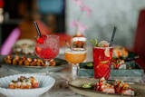 Close-up shot of three cocktails on a restaurant table filled with delicious food