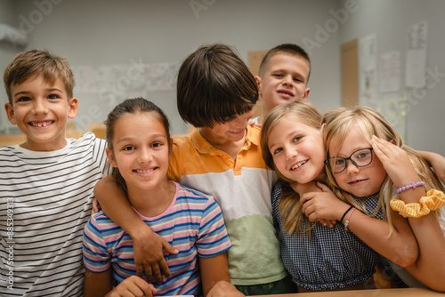 group of young students have fun and hug each other in the classroom