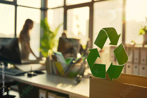 Office with recycling bin and employees in background promoting green and sustainable workspace. Eco-friendly office, recycling initiatives, workplace sustainability, environmental awareness.