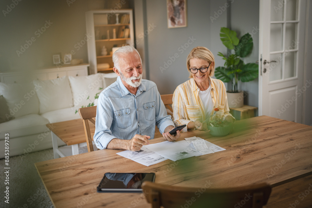 Senior couple read paper bills and invoice and discuss about payments Senior couple read paper bills and invoice and discuss about payments