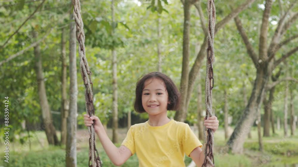 Adorable asian young girl swings joyfully in an outdoor surrounded by trees. It shows the essence of childhood play, happiness, and adventure, highlighting the carefree spirit and serenity of nature. Adorable asian young girl swings joyfully in an outdoor surrounded by trees. It shows the essence of childhood play, happiness, and adventure, highlighting the carefree spirit and serenity of nature.