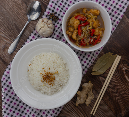 ginger chicken with rice, with uncooked ingredients as garnish photo