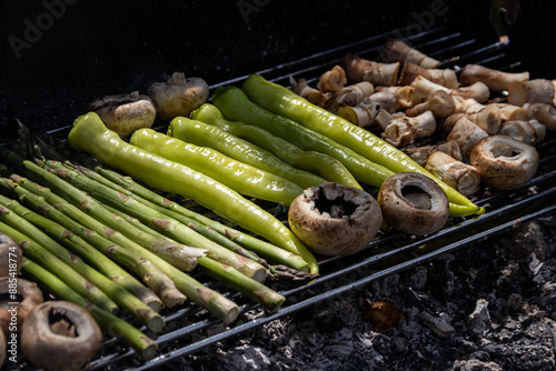 Smoking BBQ grill with mushrooms, asparagus, and green peppers, sizzling and charred to perfection, capturing the essence of delicious outdoor cooking. photo