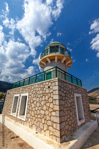 Beautiful lighthouse in Antikyra, Boeotia, Greece, under a vibrant blue sky, showcasing the stunning architectural design and offering a picturesque view of the surroundings. photo