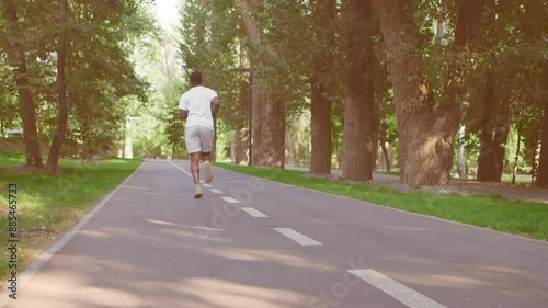 Wallpaper Mural Active black man running in empty morning park, cardio workout, back view, slow motion Torontodigital.ca