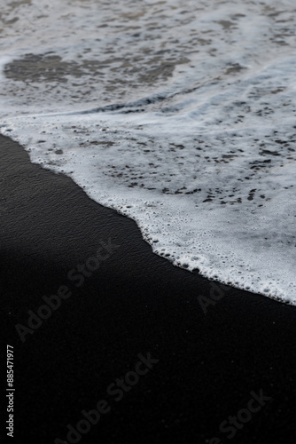 Obraz na płótnie Close-up view of some waves crashing on a black sand beach. Natural background, wallpaper. Iceland. w salonie