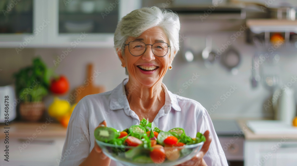 Elderly woman cheerfully presenting a bowl of fresh salad in a well-lit kitchen, embodying healthy living and joy. Elderly woman cheerfully presenting a bowl of fresh salad in a well-lit kitchen, embodying healthy living and joy.