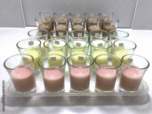 A lineup of sample glasses for sensory testing of dairy products in various flavors. This detailed setup showcases a professional quality control process. photo