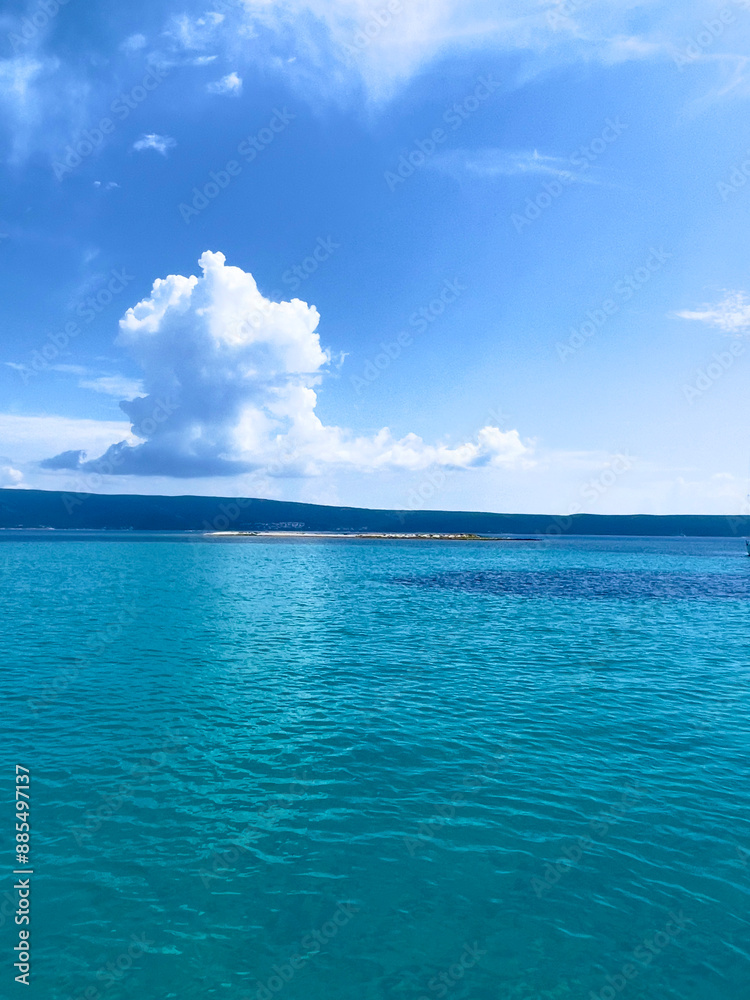 a blue ocean with a white cloud in the sky a blue ocean with a white cloud in the sky