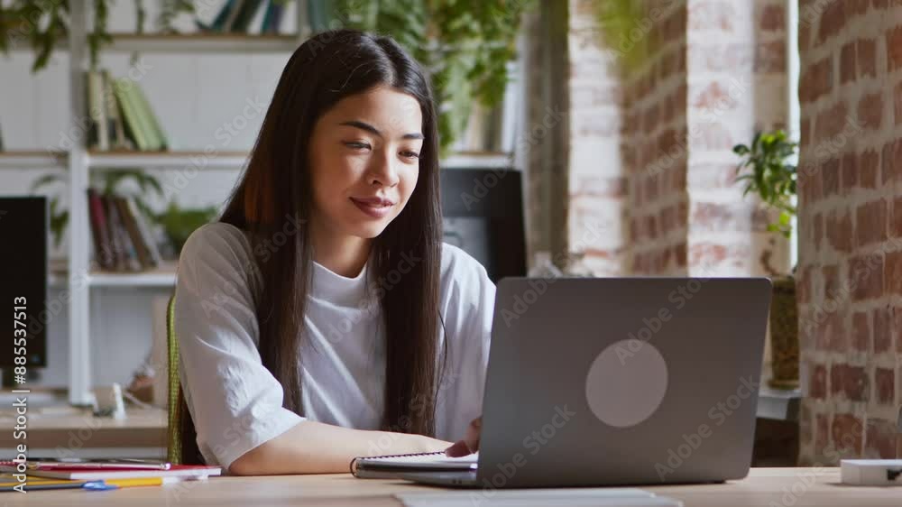 Remote communication. Young asian girl greeting with groupmates via video chat on laptop Remote communication. Young asian girl greeting with groupmates via video chat on laptop