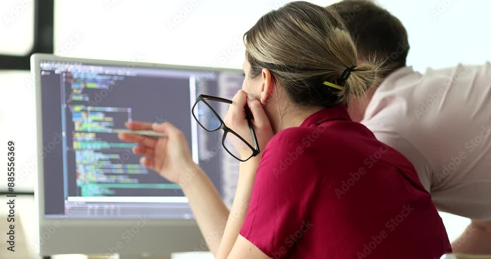 Programmers discuss code structure looking at monitor in office. Project manager with engineer checks up digital data. Software development technology