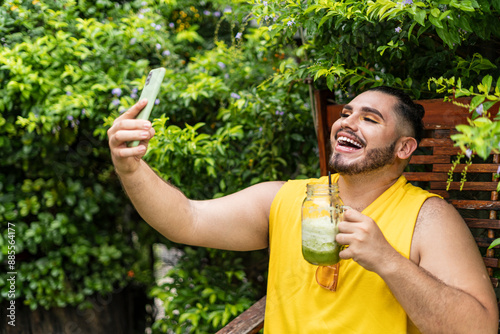 Young LGBT male enjoying his drink while taking a photo photo