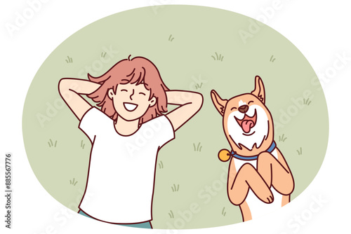 Little girl and dog lie on grass in backyard of house and enjoy sunny summer day. Laughing teenage girl with red dog shiba inu relaxing on lawn enjoying local pastime during vacation
