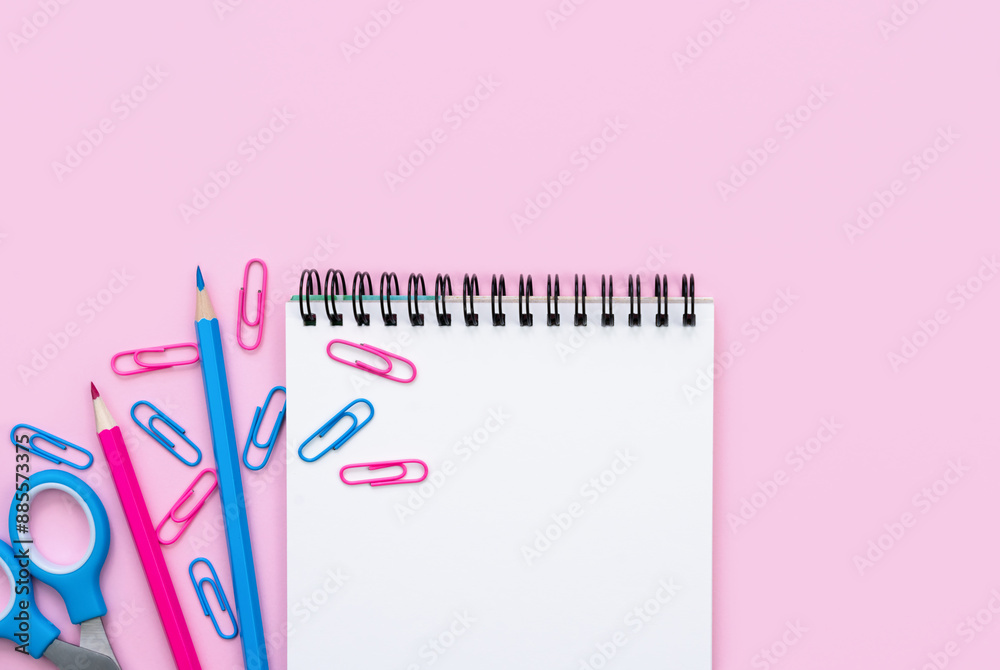Empty notebook, pencils and paperclips on a pink background. Flatlay. Teacher's Day. Back to school. Top view. Copy space. Empty notebook, pencils and paperclips on a pink background. Flatlay. Teacher's Day. Back to school. Top view. Copy space.