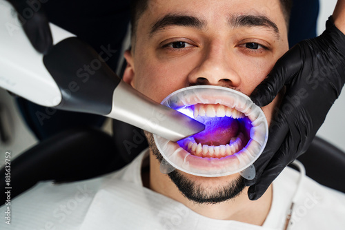 Doctor examines teeth of patient with x-ray scanning equipment. Dental intraoral scanner used by orthodontist in stomatology clinic. photo