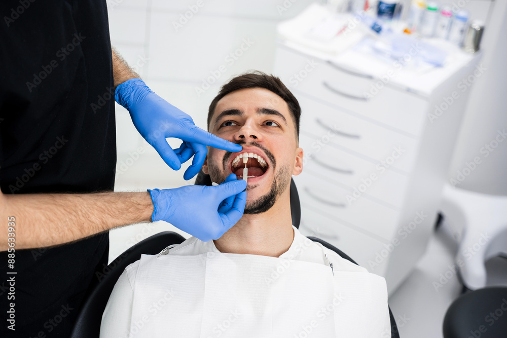 Fototapeta premium Analysis of patients tooth shade by dentist. Patient chooses tooth shade before bleaching.