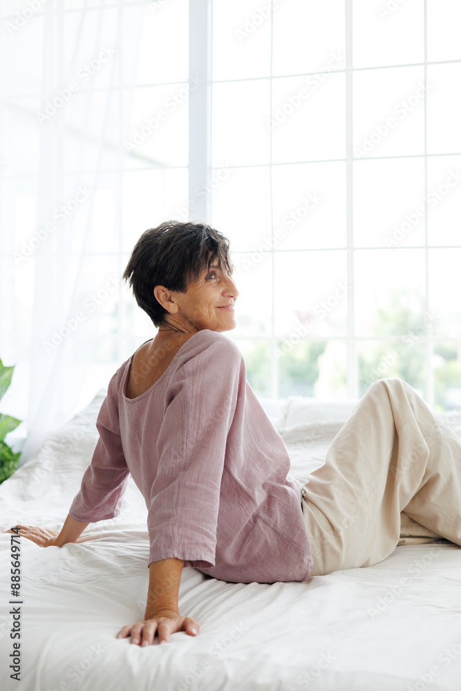 Smiling mature woman relaxing on bed in morning Smiling mature woman relaxing on bed in morning