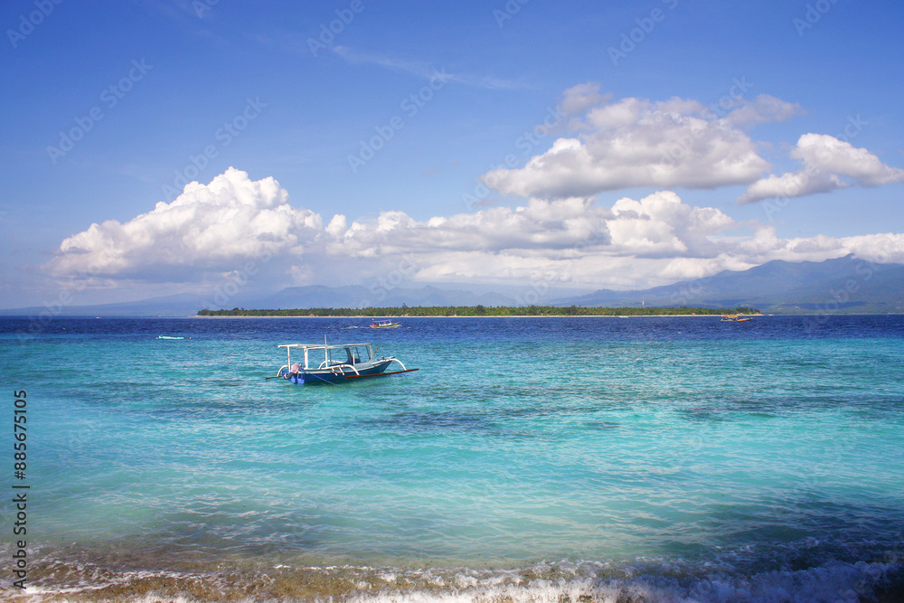 Small tourist boat in the serene turquoise waters of a tropical Gili Meno island on a clear sunny day Small tourist boat in the serene turquoise waters of a tropical Gili Meno island on a clear sunny day