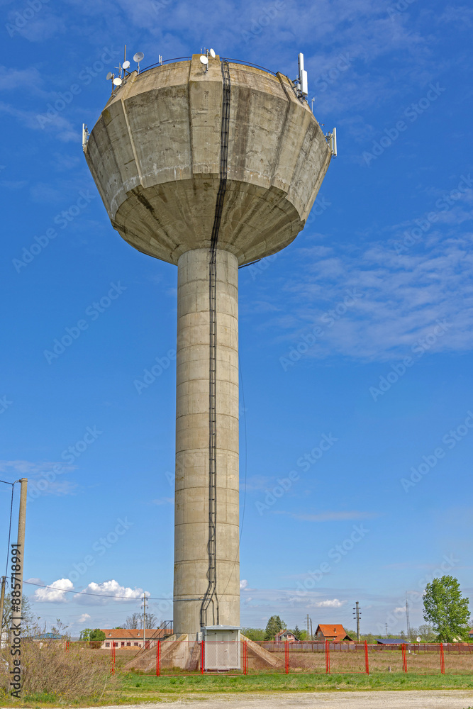 Tall Concrete Tower Water Supply for Village With Wireless Antennas Blue Sky Spring Day Tall Concrete Tower Water Supply for Village With Wireless Antennas Blue Sky Spring Day