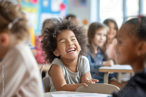 Happy child with curly hair smiling at classroom table © Edifi 4