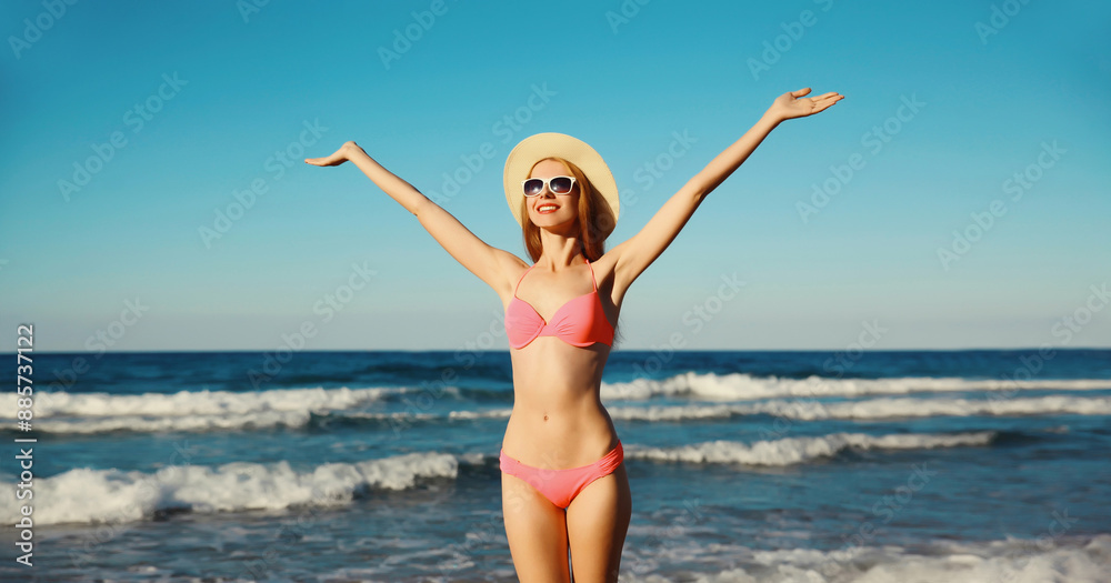 Summer vacation, happy joyful woman in bikini swimsuit, hat on the beach on sea coast with waves Summer vacation, happy joyful woman in bikini swimsuit, hat on the beach on sea coast with waves
