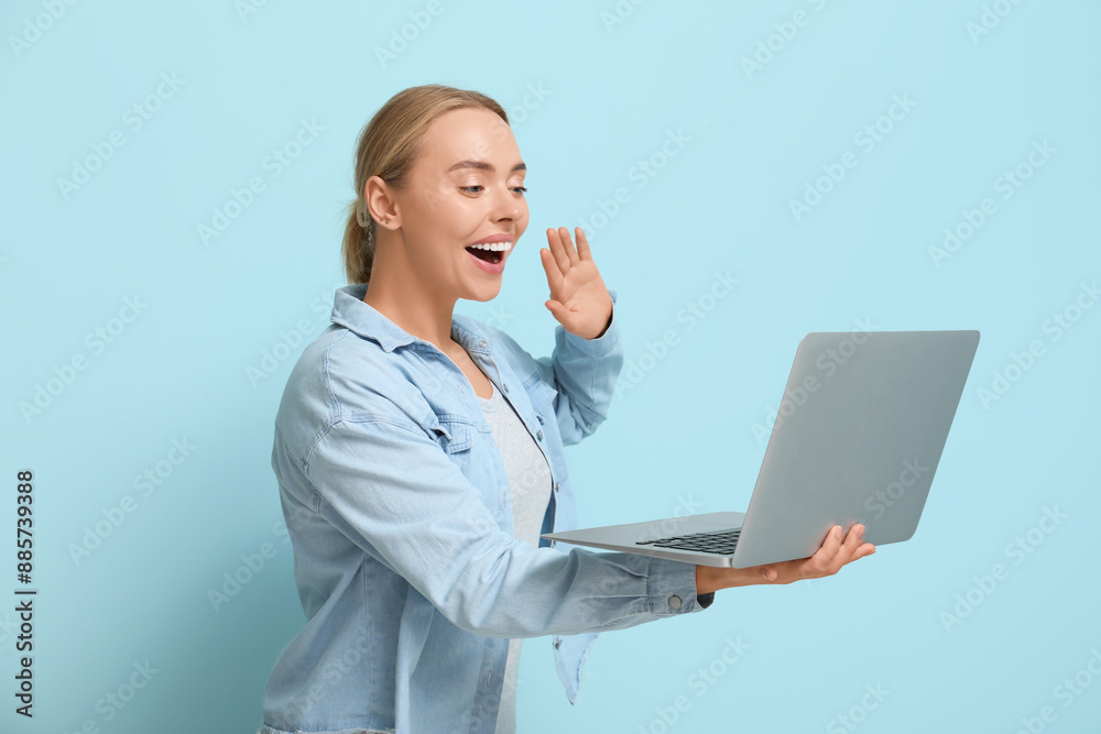 Happy young woman with laptop waving hand on blue background Happy young woman with laptop waving hand on blue background