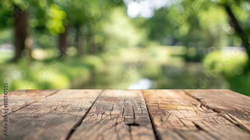 In the foreground, a selected focus empty wooden table with copy space stands, with the background fading into a blur of a serene park
