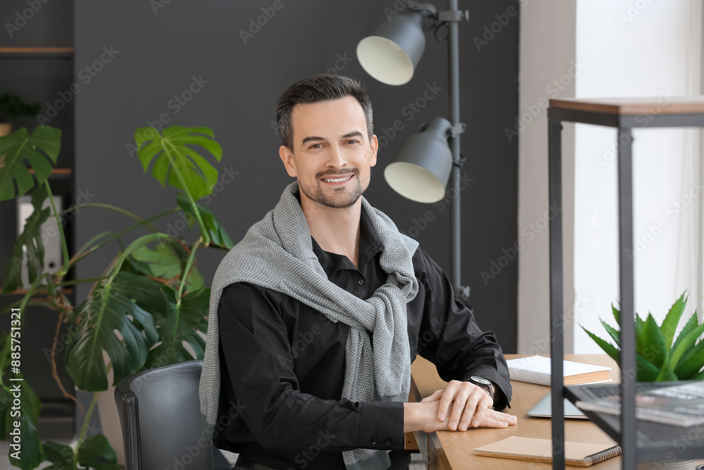 Handsome businessman sitting at table in office