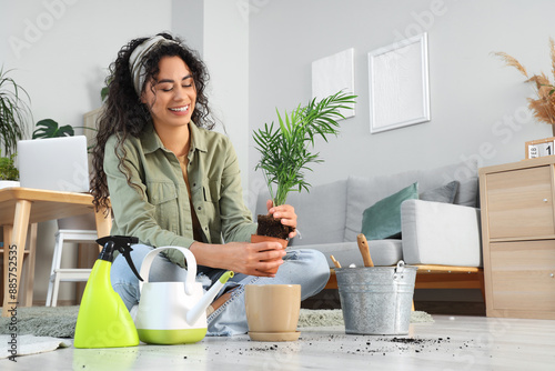 Happy young woman repotting...