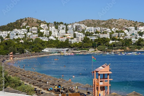 Fototapeta Naklejka Na Ścianę i Meble -  July 9, 2024, Vouliagmeni, Greece. View of the beach, bay and town at the Kavouri resort area, on a hot summer afternoon
