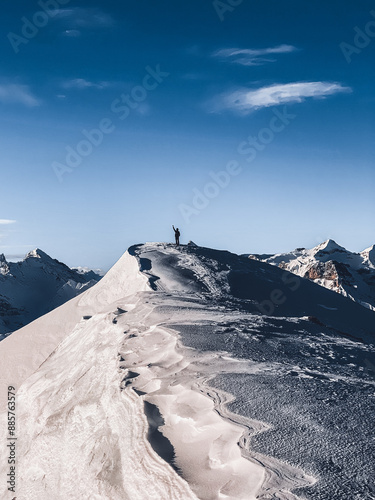 Mountaineer on top of a snowy mountain peak