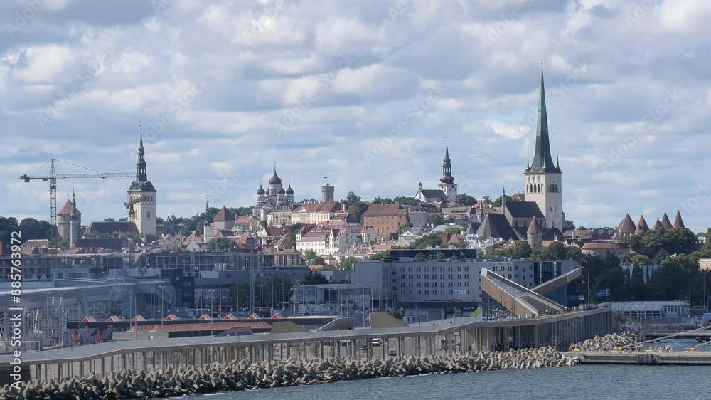Tallinn.Estonia-July 21.2021: Awesome shot of the old town of Tallinn viewed from the sea. Beautiful architecture. Harbor. Churches. Cloudy sky. Camera slowly moving sideways. Tallinn.Estonia-July 21.2021: Awesome shot of the old town of Tallinn viewed from the sea. Beautiful architecture. Harbor. Churches. Cloudy sky. Camera slowly moving sideways.